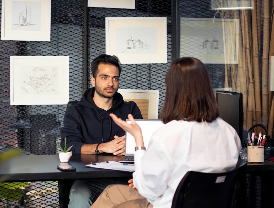 NYC web designer consulting with client in modern office, showcasing Squarespace and WordPress designs.